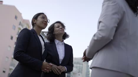 smiling businesswomen shaking hands