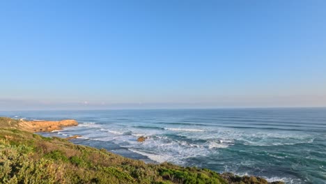 waves crashing on rocky coastline under clear sky