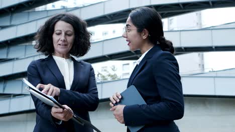 smiling businesswomen looking at papers