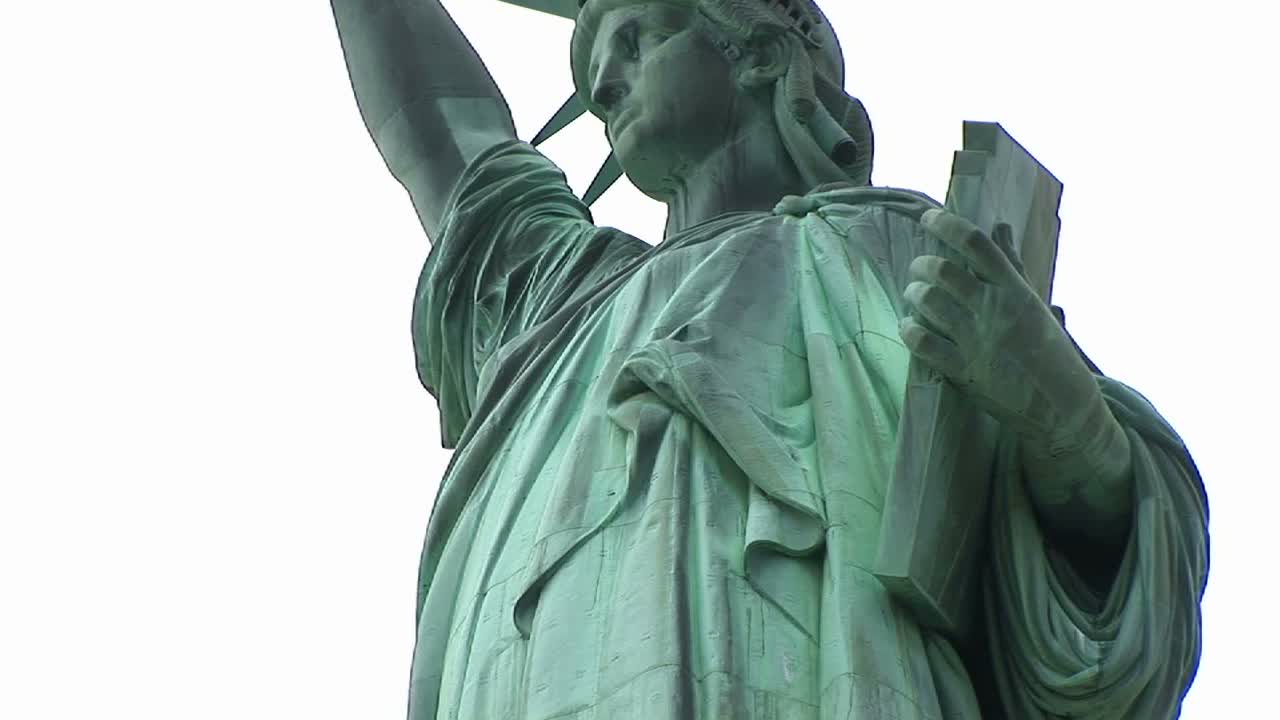 вид сверху на половину отреставрированной статуи свободы с табличкой, которую она держит в одной руке, и факелом в другой, хорошо различимым