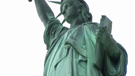 wormseye view of the top half of the refurbished statue of liberty with the tablet she holds in one hand and the torch in the other clearly visible