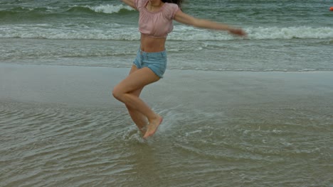 a woman dancing in the shallow waves at the beach