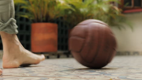 Old-fashioned-historical-brown-soccer-ball-and-bare-foot-playing-with-ball-dribble