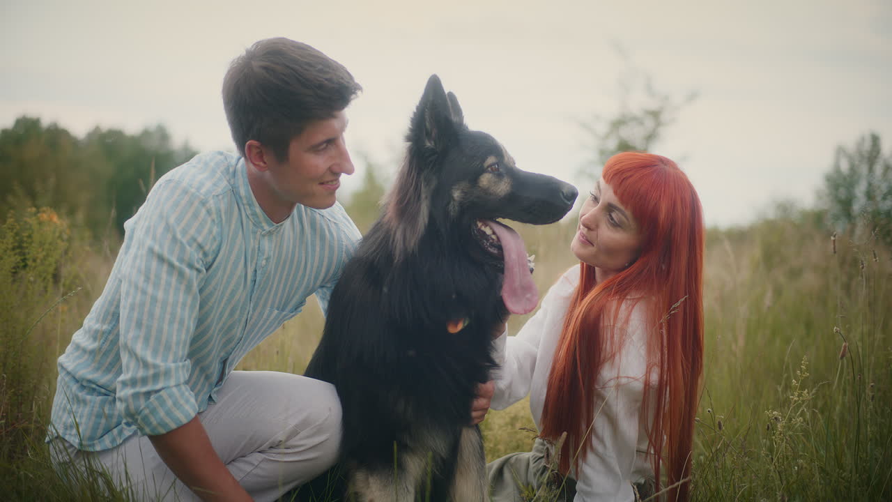 A couple with a dog in a field