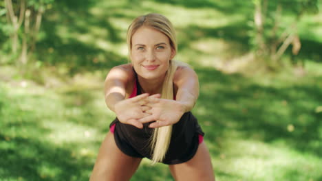 Beautiful-woman-doing-slope-and-stretching-arms-at-outdoor-training-in-park