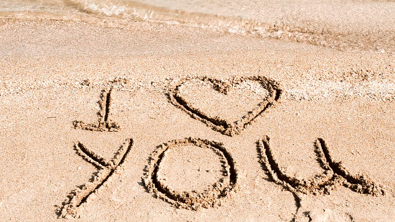 Inscription I love you on sand. Shooting on the beach