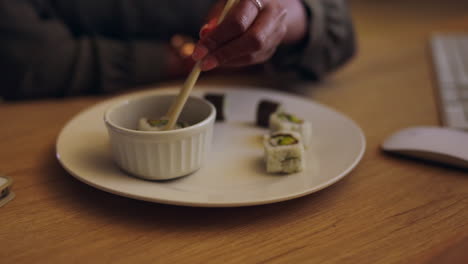 sushi, chopsticks and a business person eating