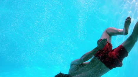 Fit-man-swimming-underwater-in-the-pool