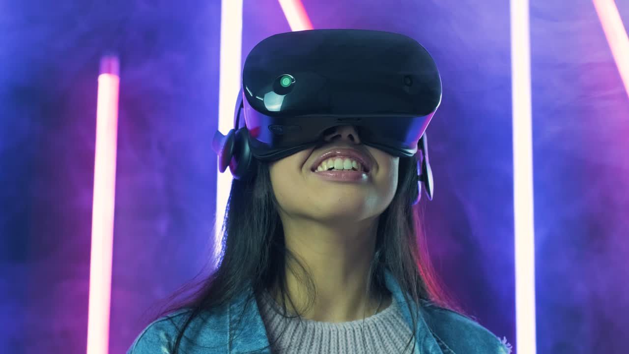 giovane donna che dice wow, si guarda intorno e si chiede come incredibile nell'auricolare vr. casco di realtà virtuale su sfondo di luce a colori fumo