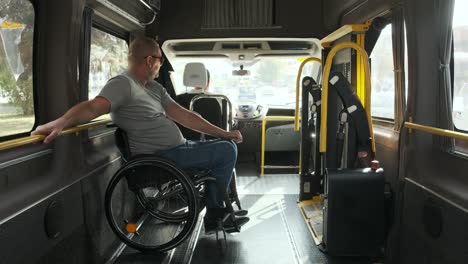 man in wheelchair in the special the vehicle. the disabled person is transported in a special car. transportation of disabled people in a special car, bus.