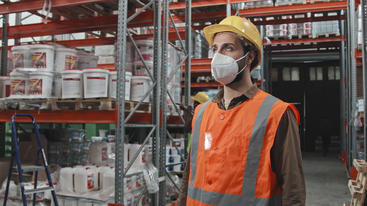Portrait of Male Worker in Face Mask Posing in Warehouse