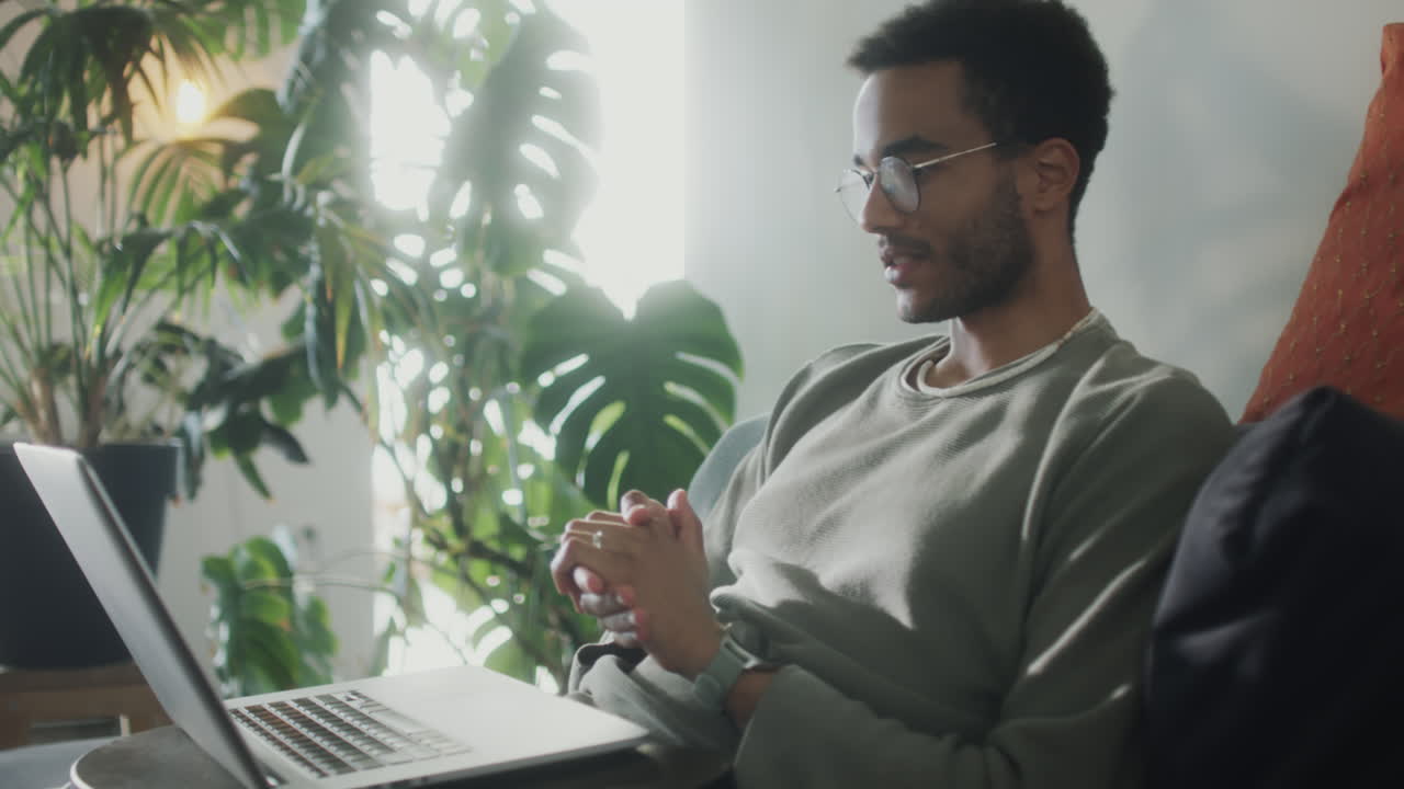 Man Speaking on Web Call on Laptop at Home