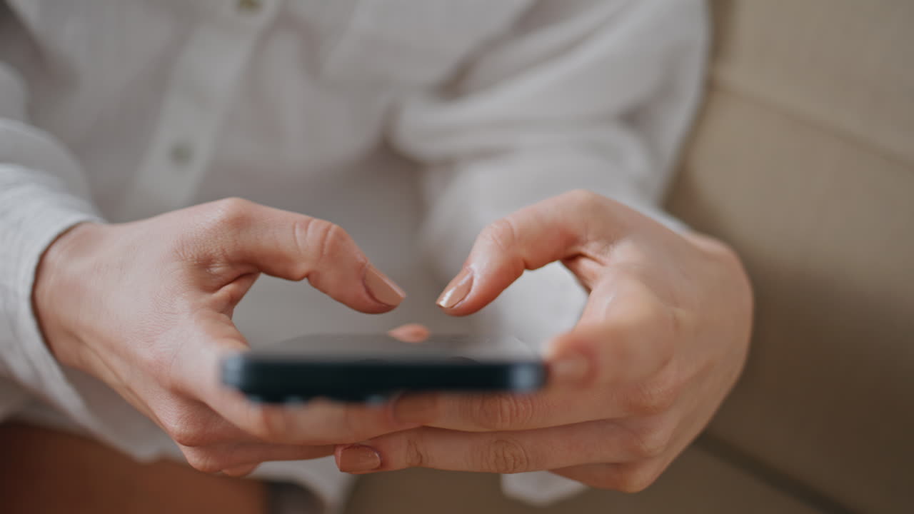 Closeup woman hands texting smartphone indoors. Female fingers touching phone