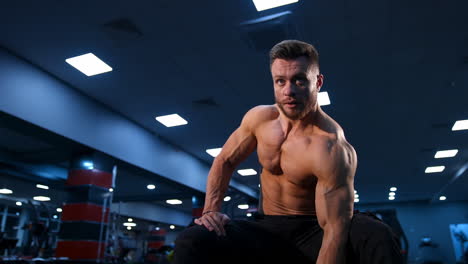 fit muscular man exercising with dumbbells. muscular young man lifting weights on dark gym background. slow motion.