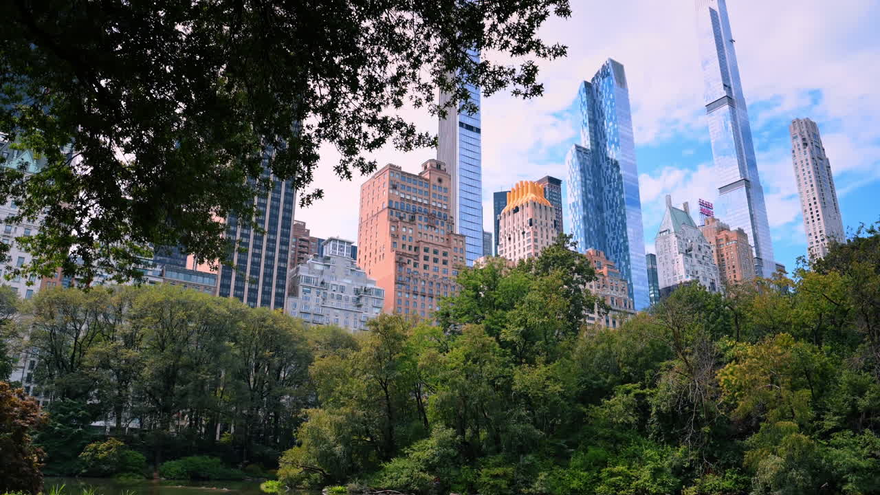 Nova York, EUA, 25 de agosto de 2025: Lago do Central Park com reflexo de arranha-céus em Nova York. Vista panorâmica do lago cercado por árvores verdes com reflexo dos edifícios de Midtown Manhattan na água.