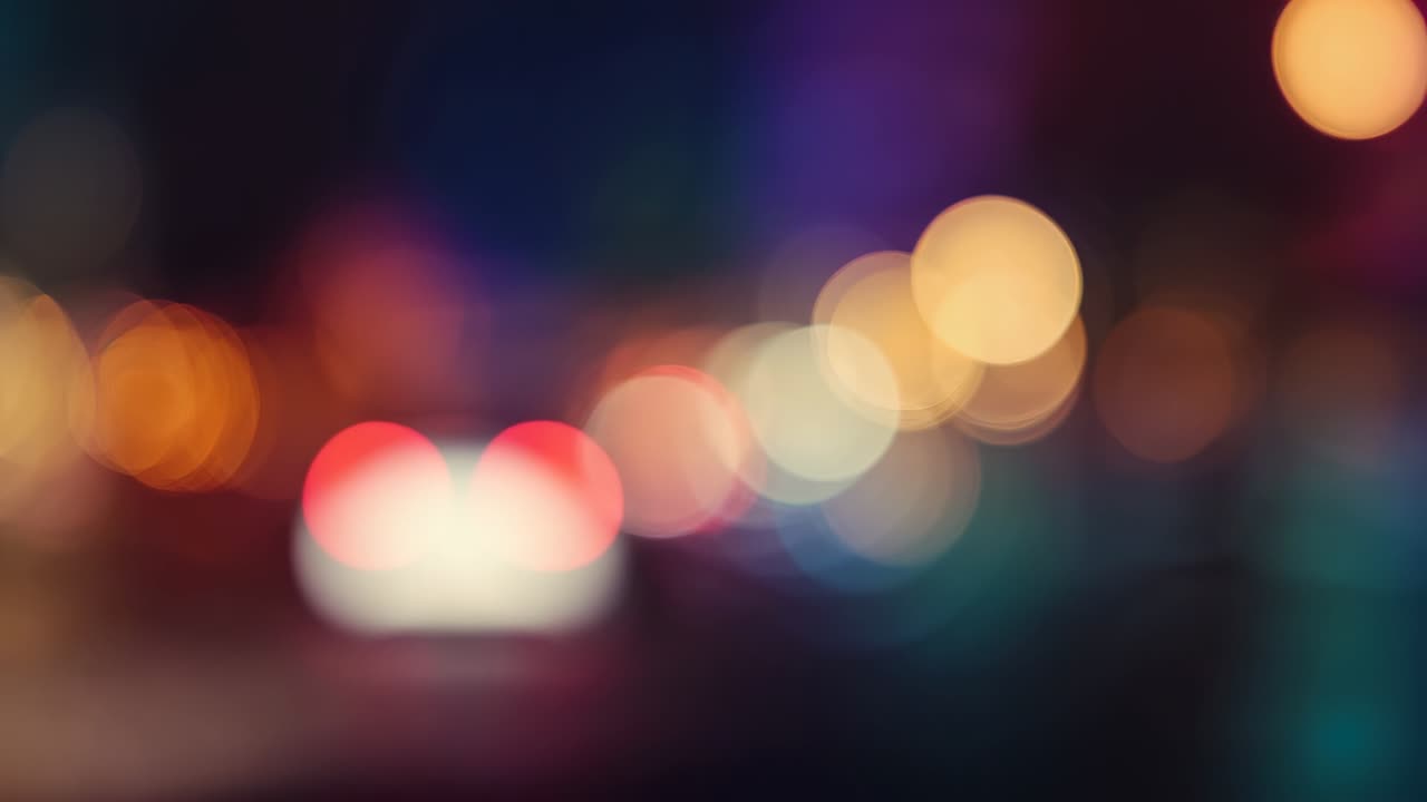 Shifting focus revealing taillights and plate light moving along dark street with bokeh, copy space