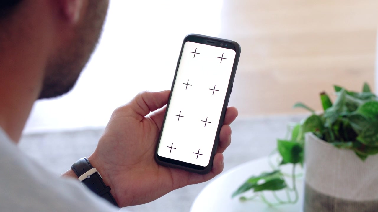 Uomo che tiene in mano uno smartphone con indicatori di tracciamento sullo schermo