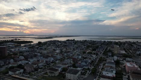 An-aerial-view-over-Arverne,-NY-during-a-cloudy-but-beautiful-sunset