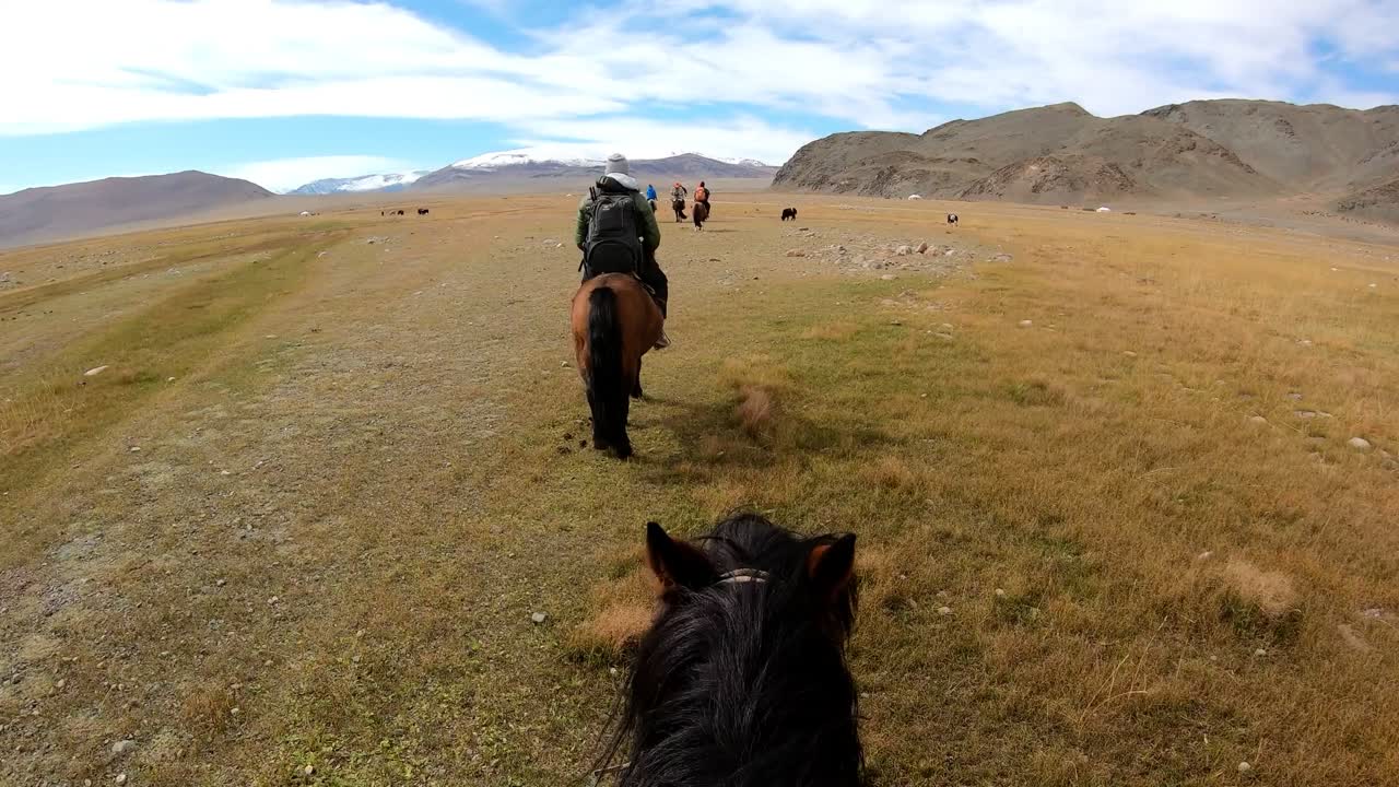 turistas a caballo con la tribu mongola en las montañas de altai, punto de vista