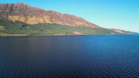 rise up and right pan over dark lake of loch lochy scottish highlands