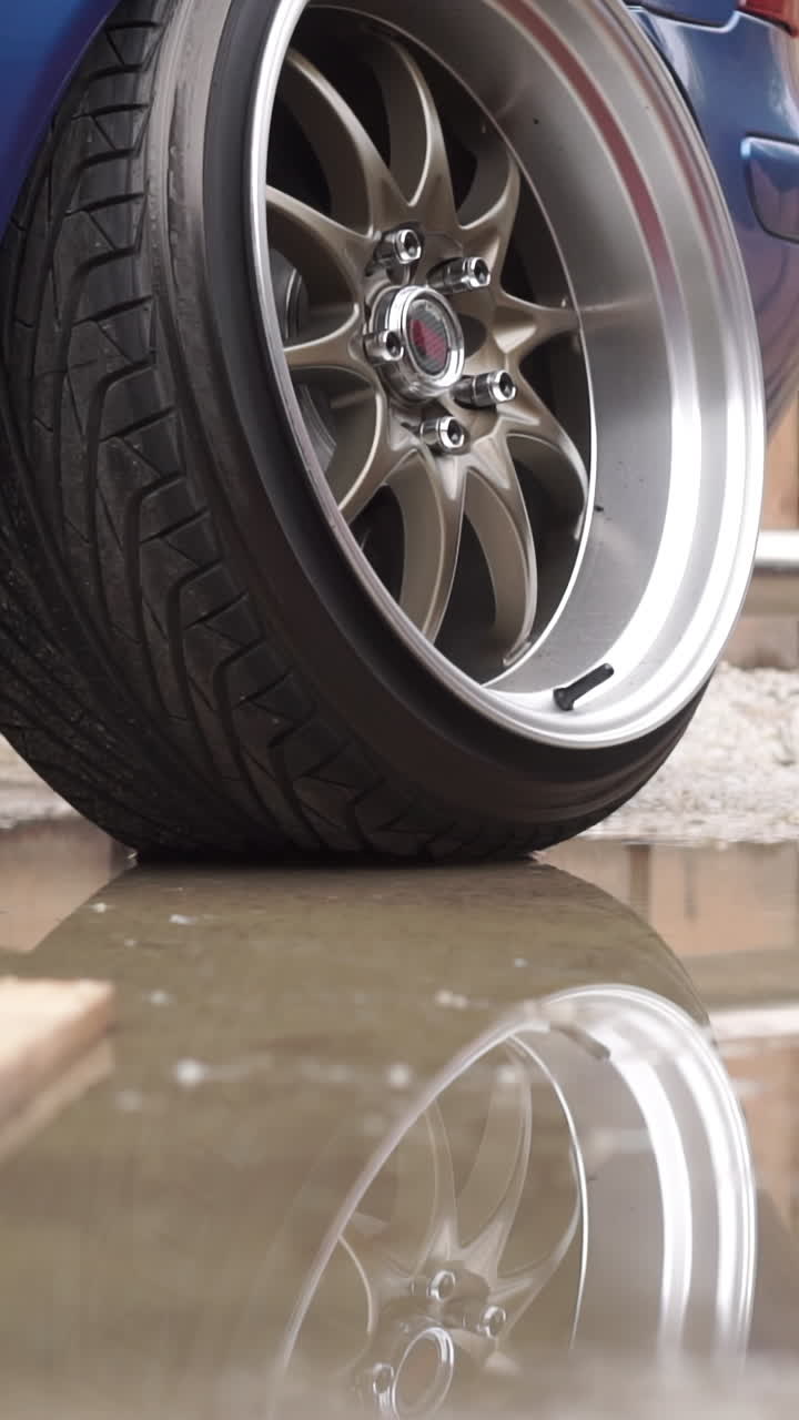 Close-up of a car wheel in a puddle