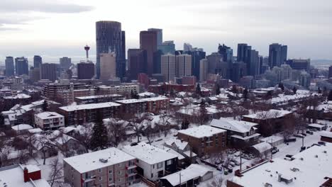 Toma-Aérea-Del-Centro-De-Calgary-En-Invierno-Y-Casas-Cubiertas-De-Nieve