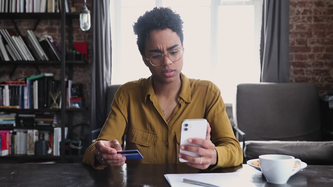Woman holds card and cellphone try making payment experiences problems