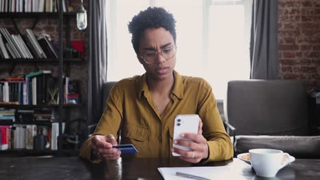 woman holds card and cellphone try making payment experiences problems