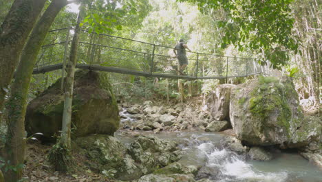 Middle-aged-male-walking-across-suspension-bridge