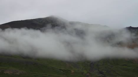 car driving past open landscape clouds in iceland