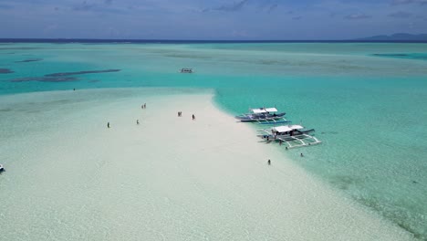 Touristen-Und-Reisende-Durchstreifen-Sandbank-Und-Flaches,-Klares-Wasser-Mit-Dem-Katamaran-Boot-Balabac