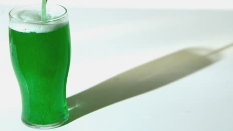 green beer pouring into pint glass