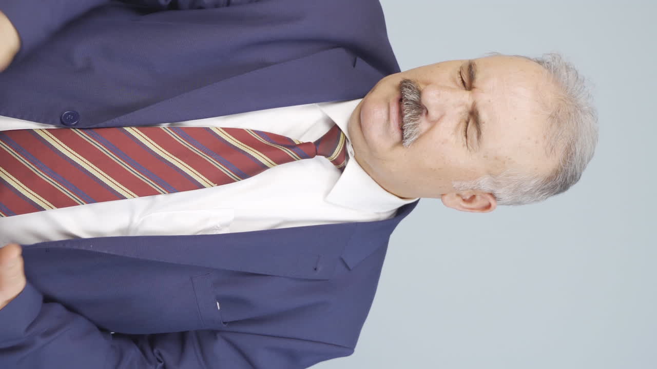 Vertical video of Bored old businessman looking at camera unhappy.