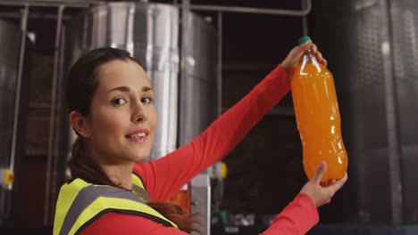 female supervisor checking juice in bottle