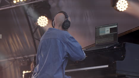 pianist performing live with laptop and headphones