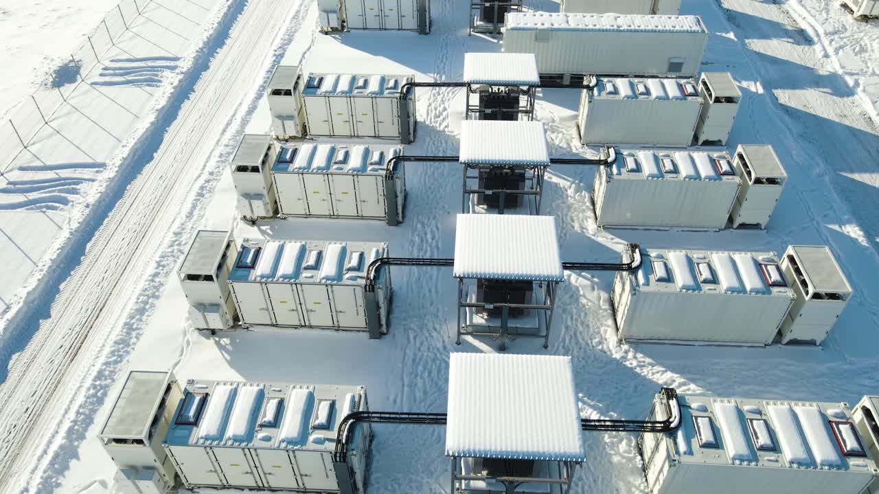 Drone move over modular electricity storage units showing detailed winter energy infrastructure