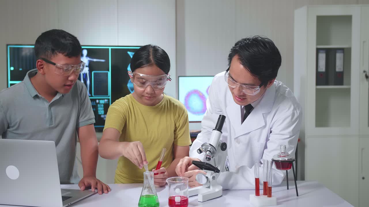 Young Asian Boy And Girl Learning Science Experiment In Laboratory With Teacher In Classroom. Study With Scientific Equipment And Tubes
