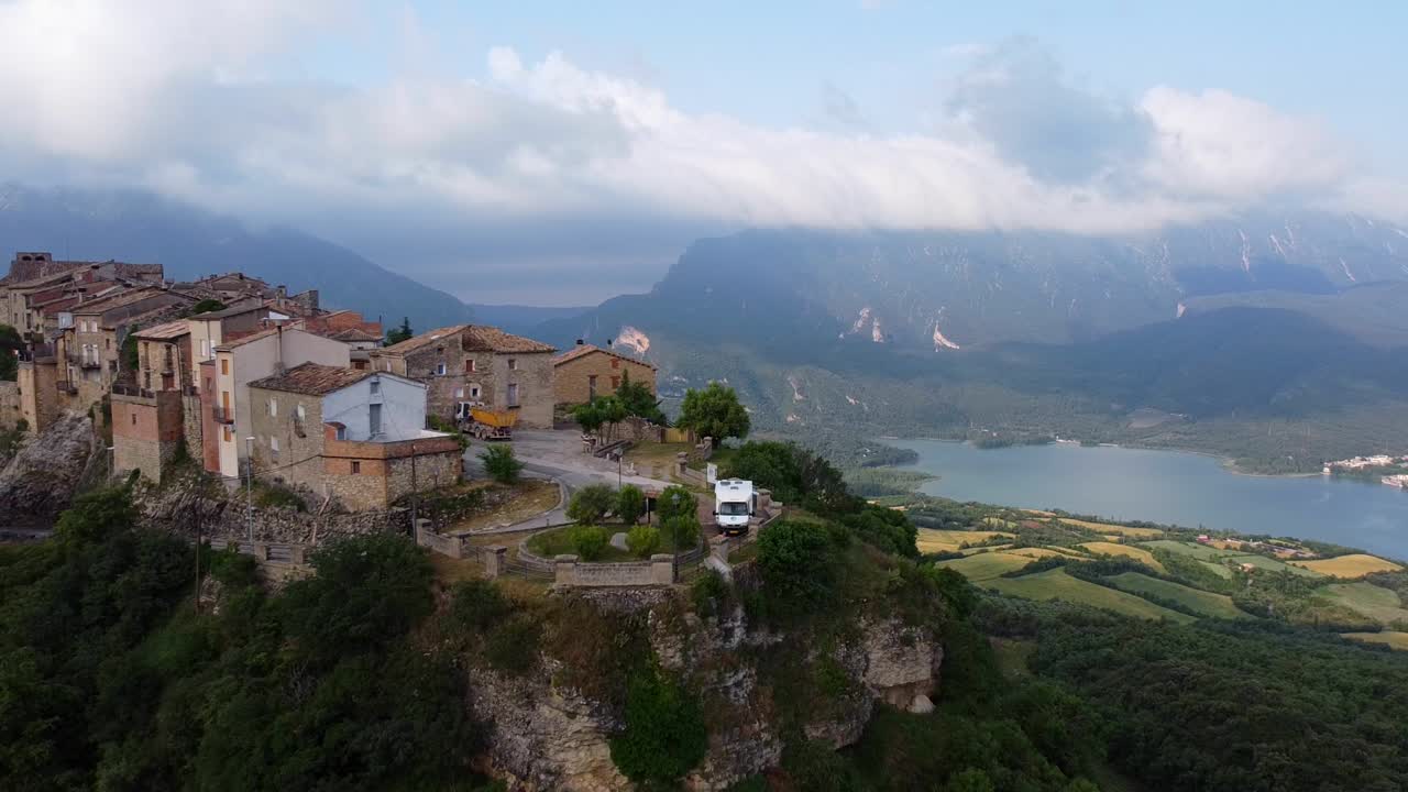 리미아나, 레리다, 카탈로니아, 스페인 북부 - 호수, 계곡, 산에서 아름다운 전망을 감상할 수 있는 언덕 꼭대기에 있는 모터홈의 공중 드론 샷