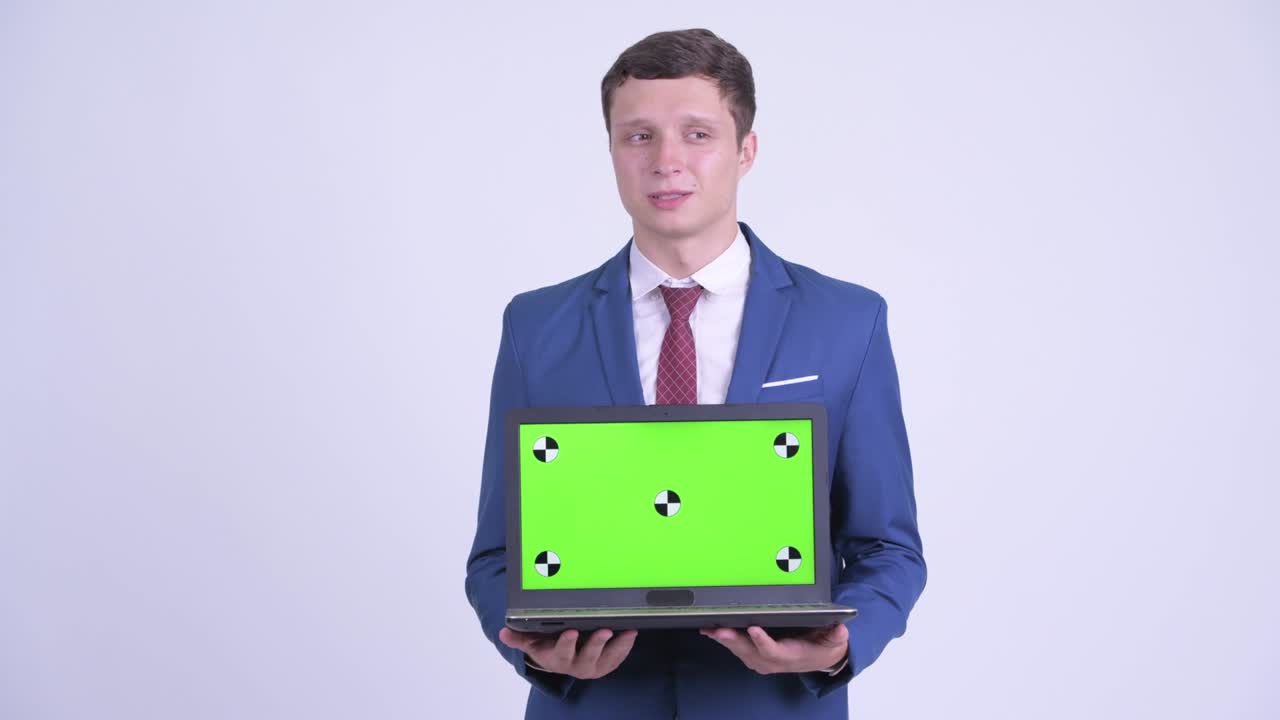 joven hombre de negocios guapo en traje con computadora portátil