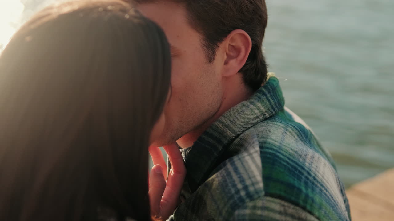 Young Couple's Romantic Kiss by the Water