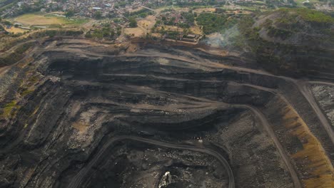 drone shot of dhanbad coal mines, capturing the contrast of dark coal deposits and surrounding landscape.