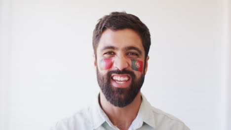 imagen de un hombre feliz del medio oriente con la bandera de portugal aplaudiendo