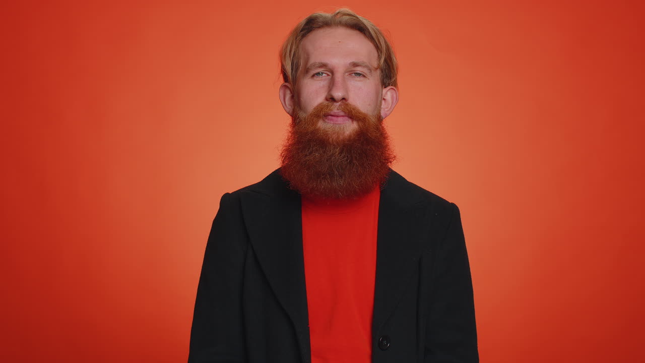 남자가 카메라를 가리키며 장난스러운 행복한 표정으로 운이 좋은 승자를 선택합니다.