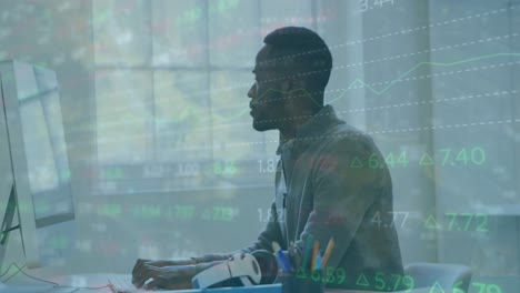 animación del procesamiento de datos del mercado de valores contra un hombre afroamericano que usa una computadora portátil en la oficina