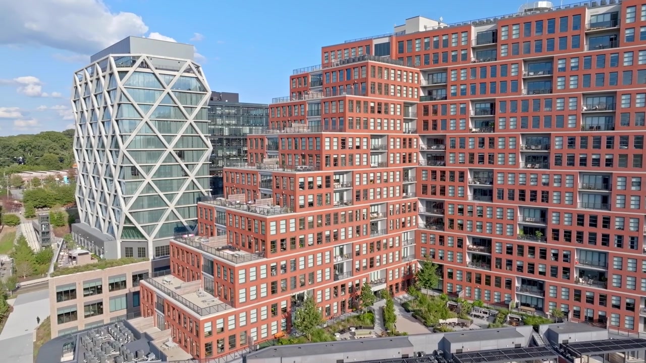 Drone voando em direção ao edifício de tijolos vermelhos das residências The Overline, revelando detalhes arquitetônicos no histórico bairro Old Fourth Ward de Atlanta, Geórgia.
