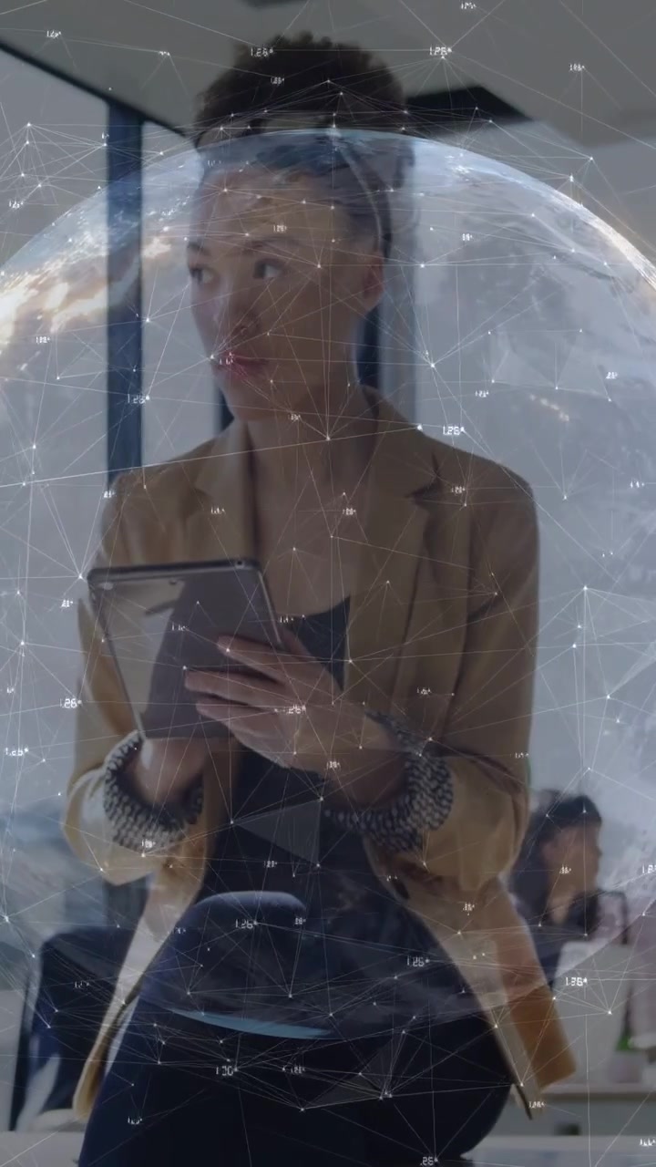 Video verticale: Donna in ufficio che tocca un tablet e attiva nodi del globo mentre analizza dati tecnologici.