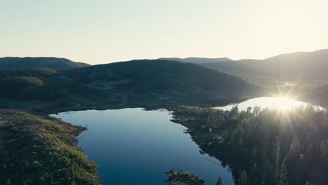 Mjøvatnet,-Indre-Fosen,-Trøndelag,-Noruega---Una-Vista-Impresionante-Mientras-La-Luz-Del-Sol-Baña-El-Lago-Y-Las-Colinas-Boscosas-Que-Lo-Rodean---Toma-Aérea-Con-Drones