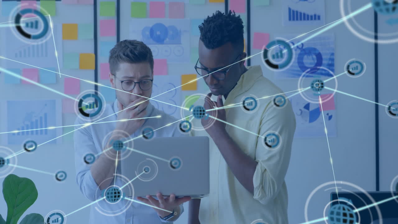 colleagues examining laptop in business office, highlighting graphs and holographic data network