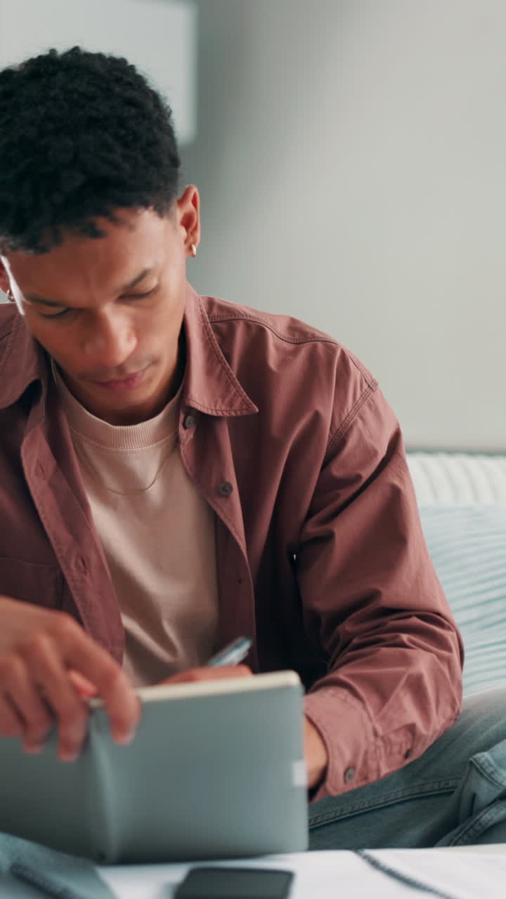 Young Man Writing in a Notebook with a Pen