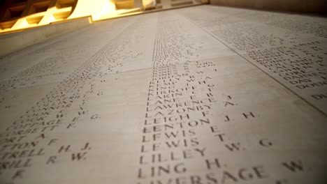 Names-of-Fallen-Soldiers-at-a-War-Memorial-Cemetery-in-Ypres-Belgium-at-sunset,-handheld-drifting-shot